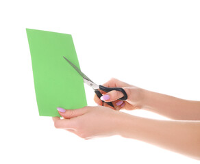 Woman cutting green paper on white background