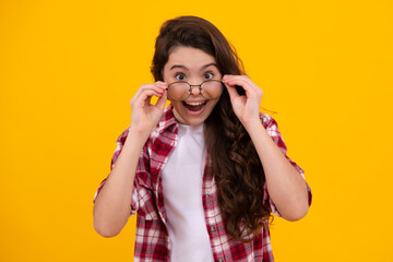 Amazed teenager. Portrait of teenager child in glasses. Kid at eye sight test. Girl holding eyeglasses and looking at camera. Vision, eyesight measurement for school children. Excited teen girl.