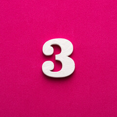 Number 3 - White wooden number on rhodamine red background