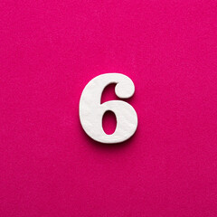 Number six - white number in wood on rhodamine red background