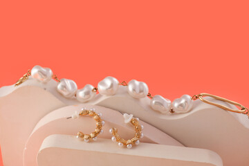 Stand with pearl earrings and bracelet on color background, closeup