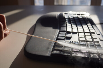 cleaning dust from computer keyboard with air pressure cleaner.