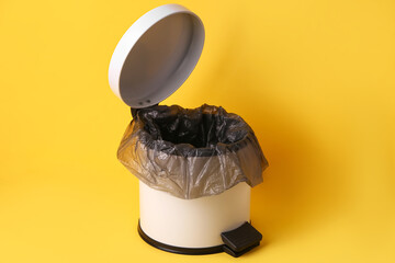 Open rubbish bin on yellow background