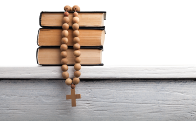 The book of Catholic and rosary beads on the wooden table