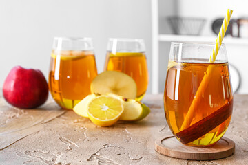 Glasses of tasty apple juice on table in kitchen
