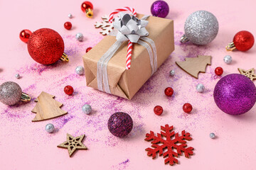 Composition with Christmas gift and decorations on pink background