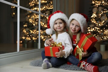 Fototapeta na wymiar Cute little children with Christmas gifts at home