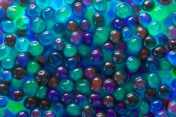 Blue green orbiz balls in water.Hydrogel balls for decoration, gardening and air humidifier.Beautiful background in cool blue and green colors.Hydrogel Orbeez background.multicolored orbiz texture.