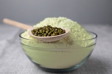 Bowl of flour and spoon with mung beans on light grey table