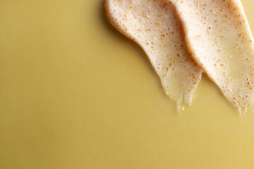 Samples of natural scrub on dark yellow, top view. Space for text