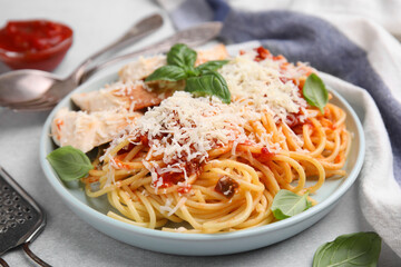 Delicious pasta with tomato sauce, chicken and parmesan cheese on white table, closeup