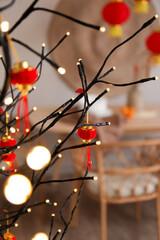 Glowing tree lamp with decor for Chinese New Year celebration in dining room, closeup