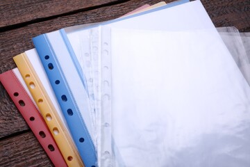 File folders with punched pockets on wooden table