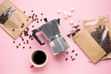 Geyser coffee maker, cup of espresso, sugar and bags with beans on pink background