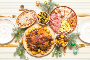 Christmas table setting with tasty food and fir branches on striped cloth, top view