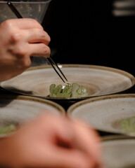Close up of a chef's hand cooking and preparing fine dining meals. Food prepping in the kitchen.