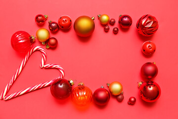 Frame made of Christmas balls and candy canes on red background