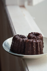 Caneles de bordeaux - traditional French sweet dessert. Canele on round white plate