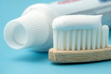 Fototapeta na wymiar New toothbrush with toothpaste closeup on blue background closeup