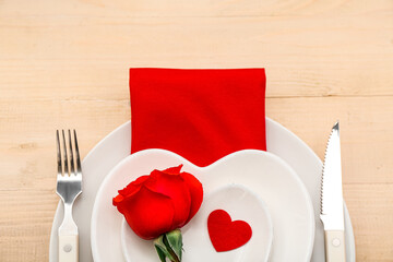 Table setting for Valentine's Day with rose and heart on wooden background, closeup