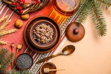 Pot of Kutya with ingredients and Christmas branches on beige background