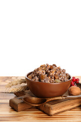 Board with bowl of Kutya and spikelets on table against white background