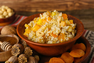 Bowl of rice Kutya, ingredients and poppy pods on tray, closeup