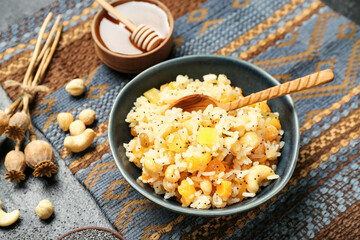 Bowl of rice Kutya, ingredients and poppy pods on dark background, closeup