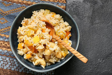 Bowl of rice Kutya with spoon on dark background, closeup