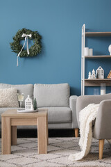 Interior of living room with Christmas wreath, sofa and table