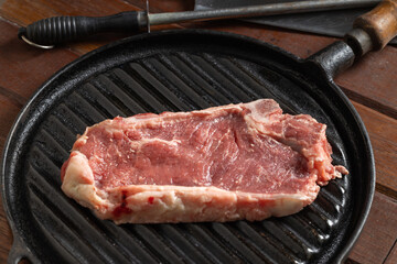 Close up of raw Argentine steak on a griddle.