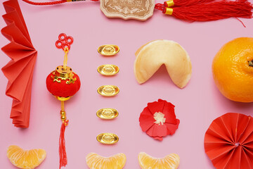 Fortune cookie, mandarins and Chinese symbols on pink background. New Year celebration