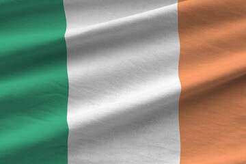 Ireland flag with big folds waving close up under the studio light indoors. The official symbols...