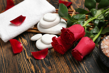 Beautiful spa composition for Valentine's Day with rose flowers, stones and towel on wooden background
