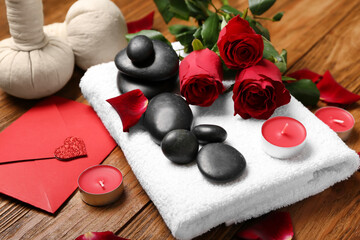 Beautiful spa composition for Valentine's Day with rose flowers, stones, towel and candles on...