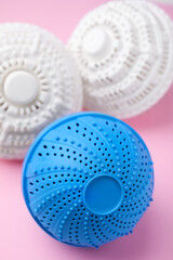 Dryer balls for washing machine on pink background, closeup. Laundry detergent substitute