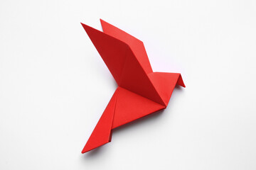 Obraz premium Beautiful red origami bird on white background, top view