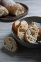 Fresh crispy ciabattas on white wooden table