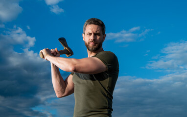 man threaten with ax. caucasian man hold ax. brutal man on sky background