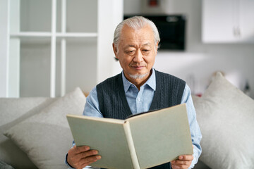 Fototapeta na wymiar senior asian man reading a book at home
