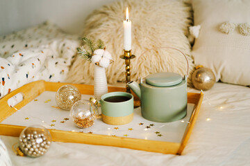 Hot tea, candle, Christmas golden balls and decorations. Christmas holiday mood in home. Winter concept.