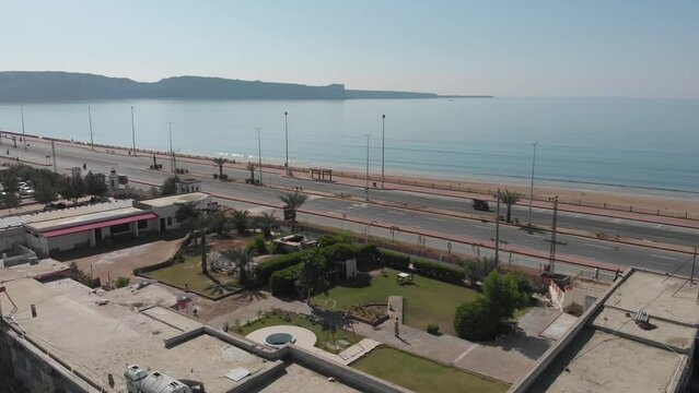 Aerial shot of car running in the street of gawadar balochistan near the beach. 