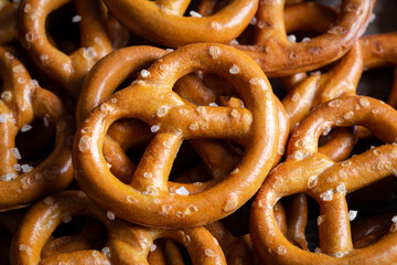 Salted mini pretzels texture background, small pretzels with salt, top view, close-up.