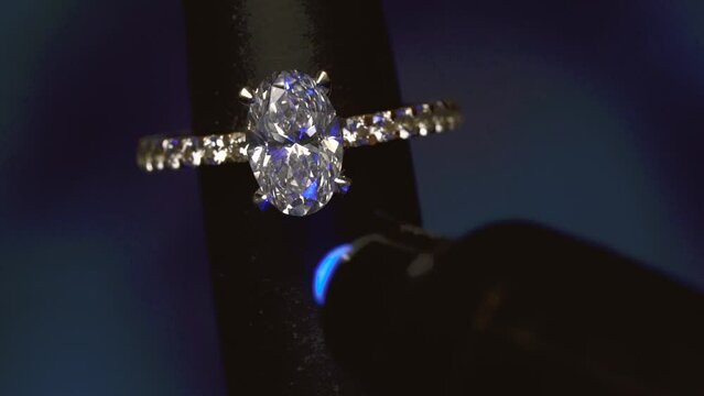 Oval Diamond Ring On Mandrel Under UV Light. - close up