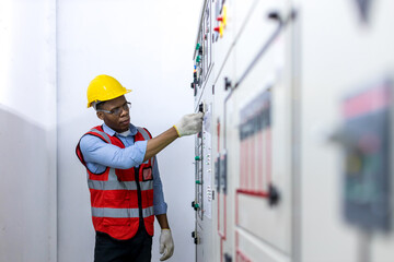 Plakat Electrical engineer working in control room. Electrical engineer man checking Power Distribution Cabinet in the control room