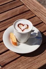 Tasse Cappuccino Kaffee mit Milchschaum mit Herz aus Kakao in einer weißen Tasse Nahaufnahme