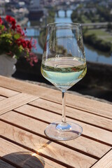 Weinglas Glas mit Weißwein Wein auf der Terrasse Holztisch des Restaurants Steinsburg im Weinberg Würzburger Stein in Würzburg