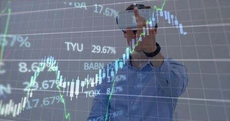 A man is using a virtual reality headset while a display of stock market information is in the backg - Powered by Adobe