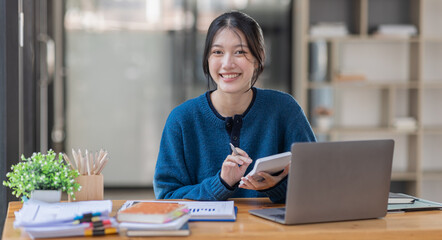Business Asian woman Using laptop computer and working at office with calculator document on desk, doing planning analyzing the financial report, business plan investment, finance analysis concept.