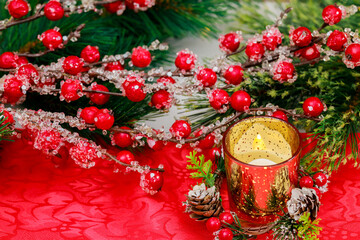 A red berry and a burning candle decorate this Christmas background.